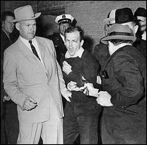 Oswald grimaces in pain as the bullet hits him
